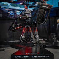 High-tech gaming simulator with 'Driven Dynamix' branding in a dark room.