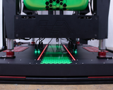 3D printer in operation with green and red lights on a white background